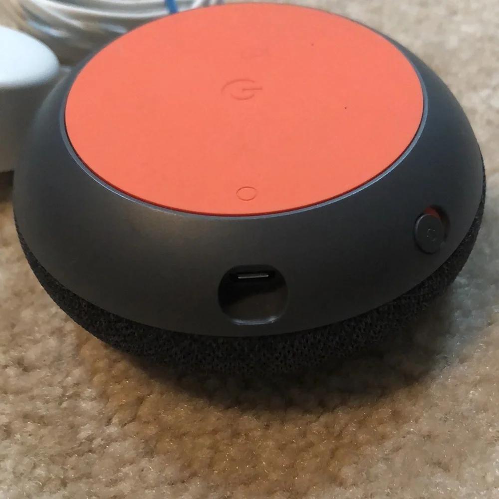 Google nest smart speaker with charger.